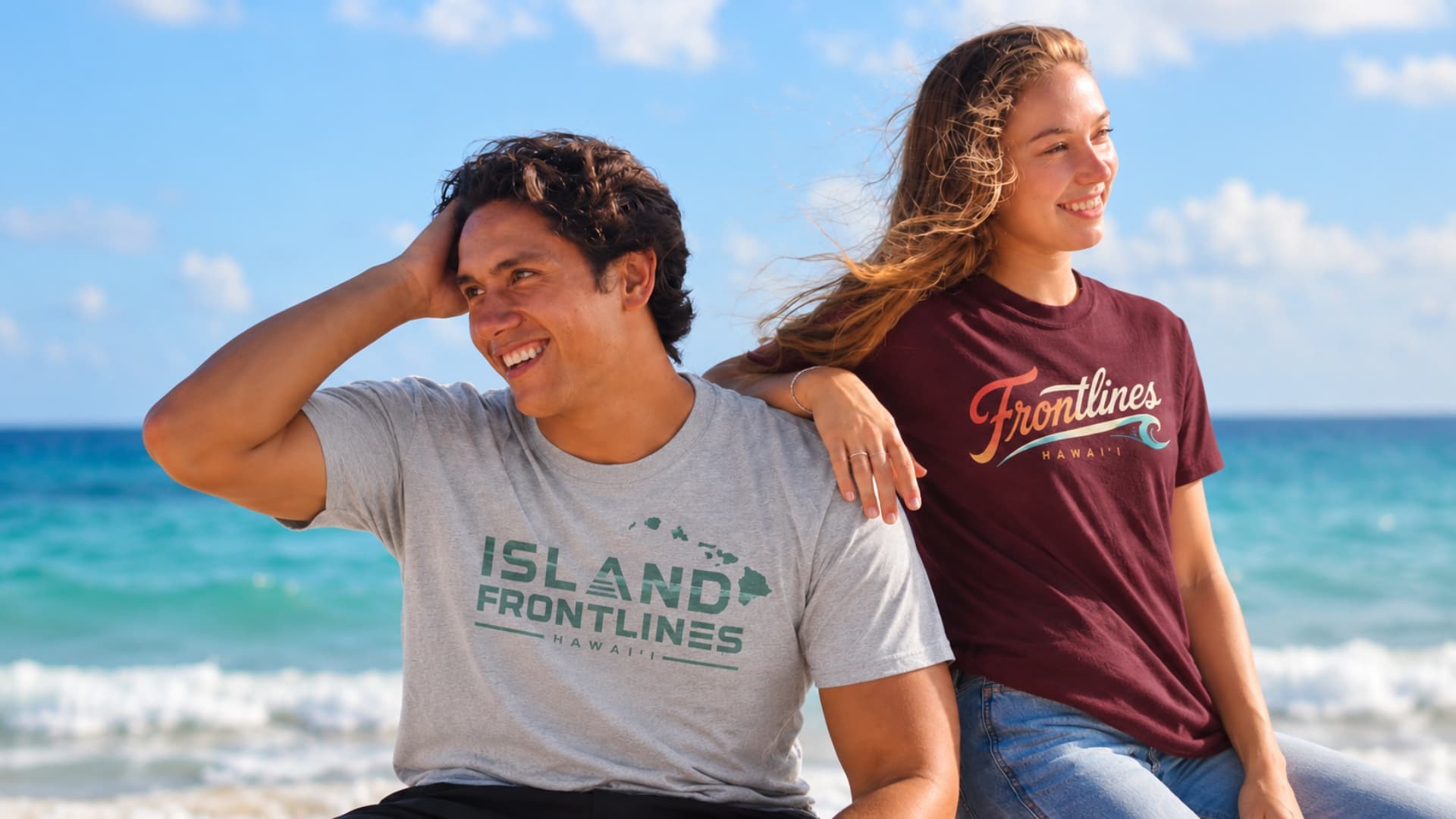 Two people wearing Frontlines graphic tees beside the ocean in Hawaiʻi