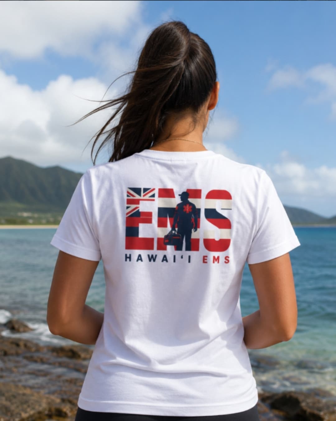 A woman wearing a Hawaiʻi EMS responder tee by the shoreline